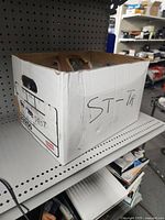 full view of cardboard box filled with assorted hardware