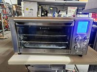 Front view of Emeril Lagasse air fryer toaster oven showing entire unit and accessories