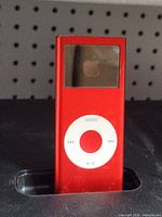 Front view of red iPod nano in dock showing screen area