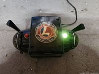 Top view powered on showing illuminated green pilot light, loose Lionel logo plate, both directional levers
