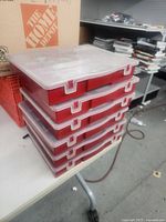Stack of six red parts organizers showing exterior and clear lids