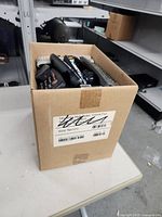 Cardboard box with remotes visible at top sitting on table