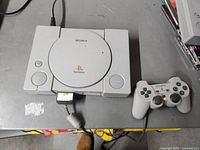 Top view of PlayStation One console, controller, memory card inserted