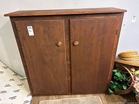 Front view of wooden cabinet with two doors and knobs