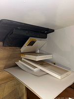 Stacked canvases and black portfolio case on shelf