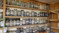 Full view of shelves with numerous glass jars of hardware