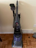 Front view of Bissell upright carpet cleaner showing tanks and brush head