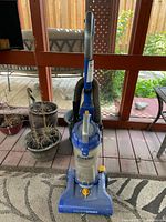 Front view of blue Eureka PowerSpeed upright bagless vacuum cleaner showing clear canister and controls