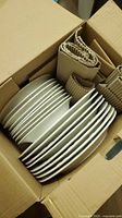 boxed stacks of white plates separated by cardboard