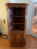 Full view of solid wood corner cabinet hutch showing shelves, lower doors, moulding and finish