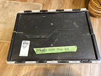 Closed black-lid tote with green tape label