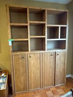 Front view of solid pine bookcase wall unit showing open cubbies and lower cabinet doors