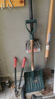 Group shot showing snow shovel blade, soil tamper on shaft, digging shovel, and loppers