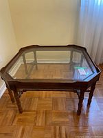 Full view of coffee table showing wood frame and glass top