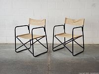Pair of folding black metal frame chairs front view