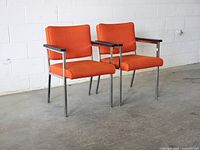 Front angled view of both chairs showing upholstery color, frames and armrests