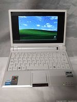 Open ASUS Eee PC netbook showing 7-inch screen, keyboard and stickers