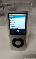 Front view of gray Apple iPod nano 4GB displaying menu within clear hard case