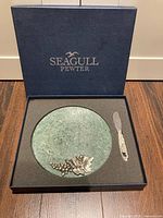 Top view of marble cheese board and pewter spreader in fitted box