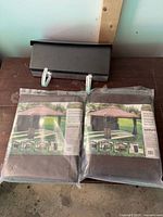 Two packaged Ashford sunshade panels and black mailbox on table