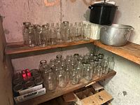 Shelving with two canning pots, many glass jars, boxes of new seals