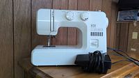 Full view of Kenmore Zip sewing machine with foot pedal on wooden surface