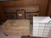 Cubby shelf, ottoman bench, and folded wooden table leaning against wall