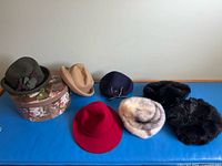 All seven hats and hat box displayed