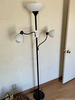 Full view of black torchiere lamp with two side lights