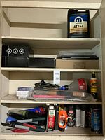 Full shelving view showing Mopar ATF jug, boxes, funnel, hand tools, aerosol cans