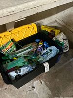 Entire tote with lid open showing assorted garden items