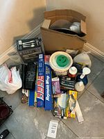 Entire lot on floor including boxed plates, cleaning jugs, wraps, sprays