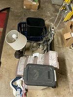 Group shot showing hand cart, lamp, wastebasket inside laundry basket, pet stairs, pet food bin and dog toy