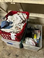 Overall lot showing red basket of rags atop two clear storage totes