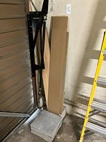 Overall view showing tile stack at base and vertical stack of flooring planks leaning against wall