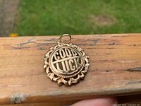 Front view of round 14K gold GOOD LUCK charm