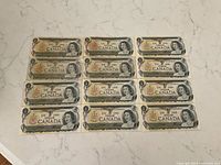 All twelve 1973 Canadian $1 bills laid flat