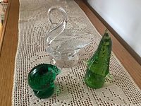 Green penguin, green loon and clear swan on lace runner