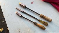 Three soldering irons laid out showing overall lengths, tips, shanks and handles