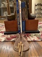 Books held between golf club bookends with pouch of tees displayed
