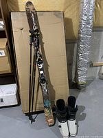 Skis, poles and boots grouped against wall