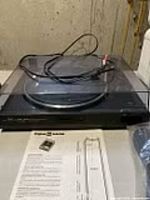 Overall view of turntable with dust cover and cables on platter