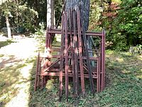 Stacked scaffold frames leaning against tree