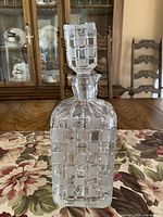 Full front view of crystal decanter with stopper in place showing square-cut lattice pattern