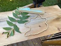 Full view of pearl necklace laid out, showing entire length and clasp