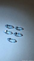 Five marquise-cut sky blue topaz stones on white background