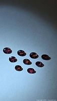 Group of nine oval pink sapphires on light background