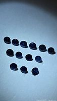 Group of 14 faceted blue sapphires on white background