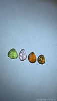 Four multicolored leaf-cut tourmaline gemstones on white background