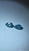 Two pear-cut seafoam blue zircons on white background